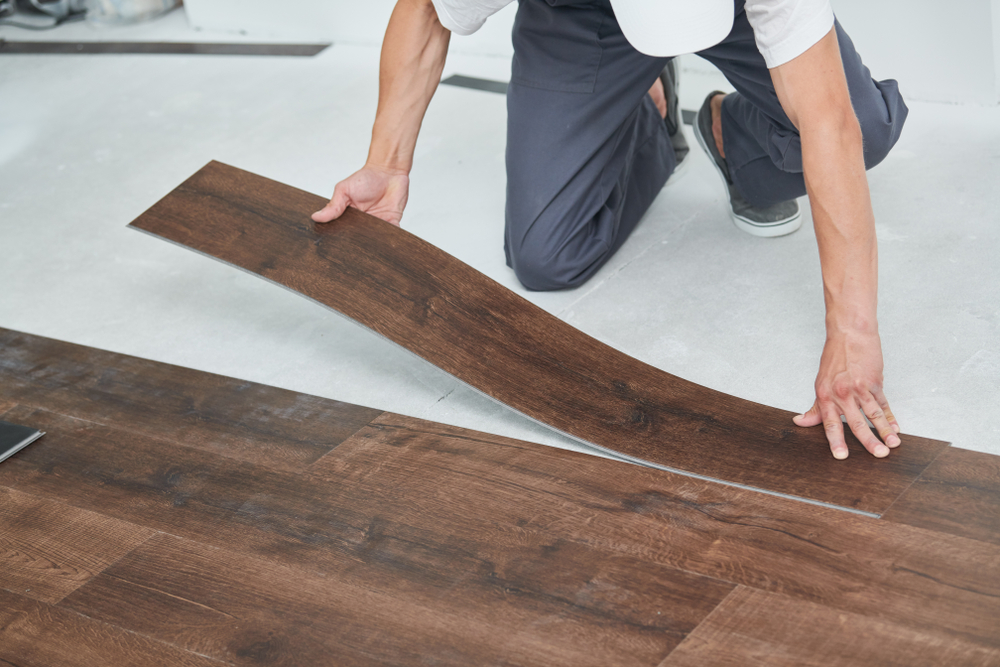 Person installing wooden flooring planks
